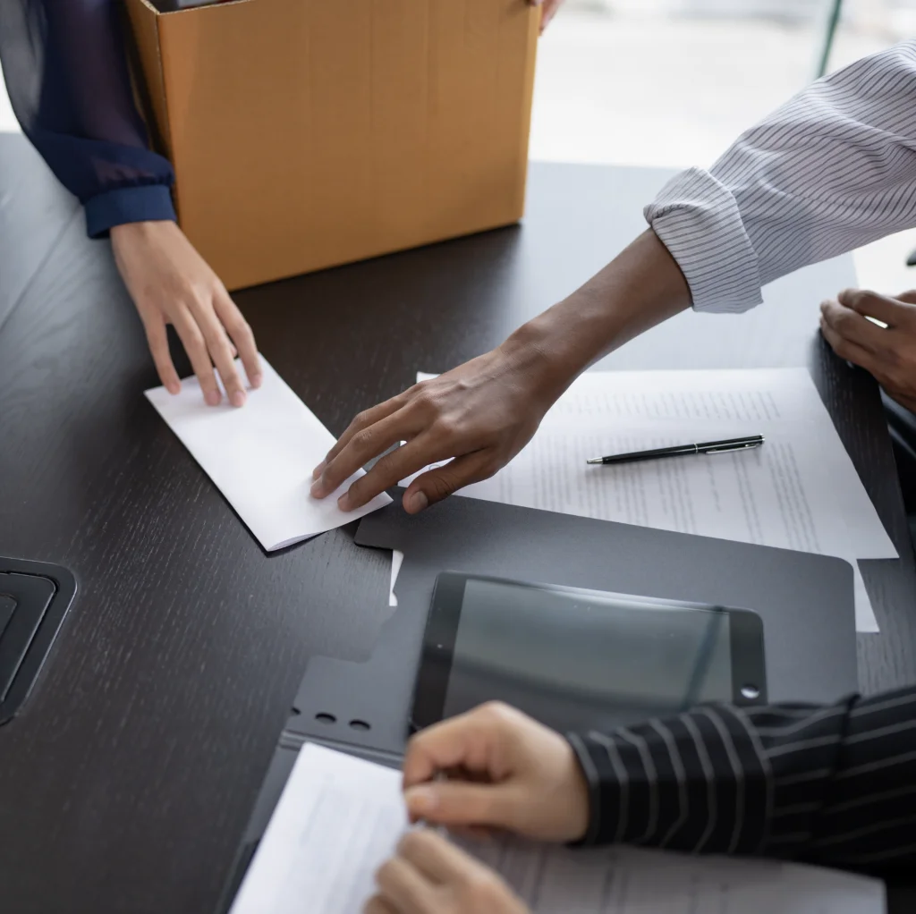 Hands on a desk passing a note to each other